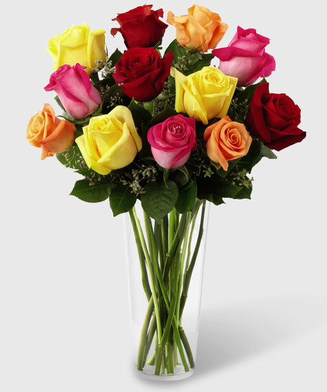 Pink, orange, red and yellow roses in a clear glass vase.