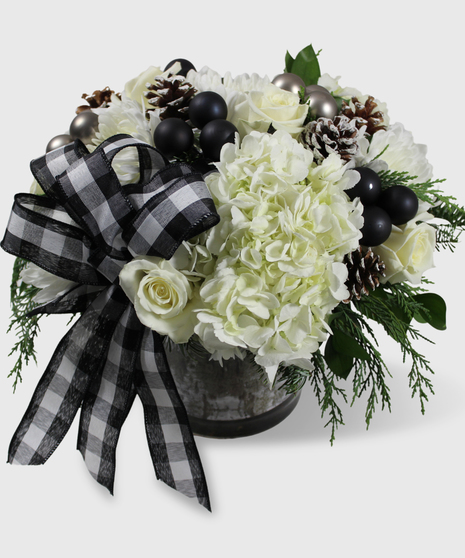 White flowers, winter greenery with black decorations in a cylinder vase