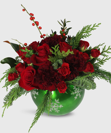 holiday floral arrangement with red roses, berries, evergreens, and more